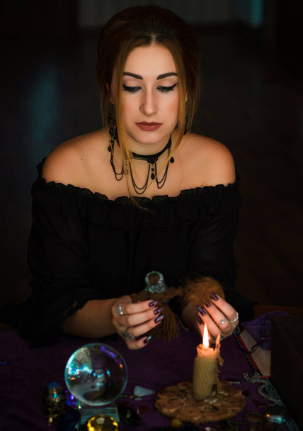 Женщина совершает ритуалы с куклой вуду и волосами, концепцию магических ритуалов и викку - Фото, изображение