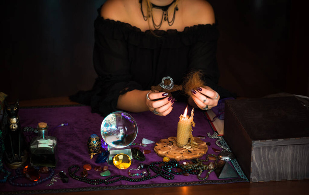 Женщина совершает ритуалы с куклой вуду и волосами, концепцию магических ритуалов и викку - Фото, изображение