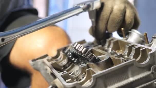 View on disassembled motor from automobile. Unrecognizable mechanic repairing car engine. Man engaged using tool for his work. Repairer working in garage or workshop. Slow motion Close up - Footage, Video