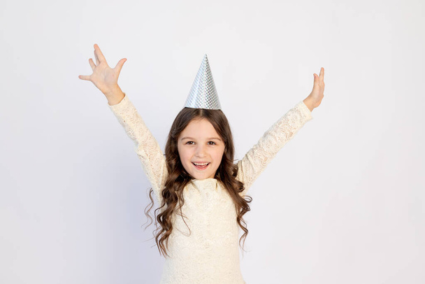 Молодая девушка в день рождения в шляпе с протянутыми руками кричит на изолированном белом фоне, молодая красивая девушка улыбается со счастливым лицом - Фото, изображение