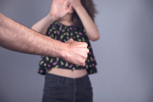 angry man beating woman on grey background - Foto, immagini