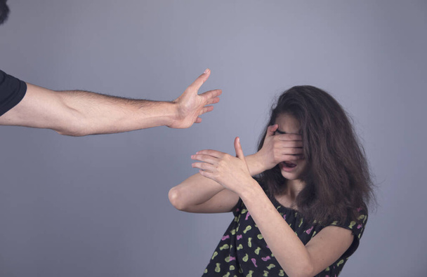 angry man beating woman on grey background - Zdjęcie, obraz