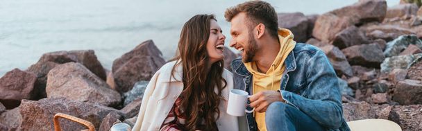 panoraama laukaus nainen nauraa lähellä poikaystävä kupin teetä - Valokuva, kuva