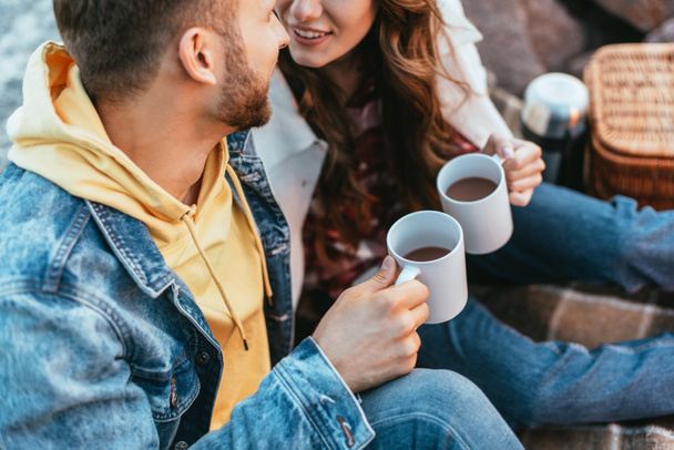 oříznutý pohled na muže a šťastnou ženu držící poháry s čajem venku - Fotografie, Obrázek