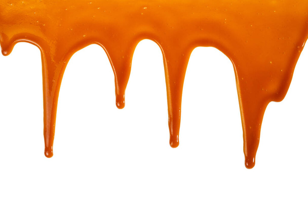 Background of flowing caramel sauce isolated on white. Copy space. - Fotó, kép