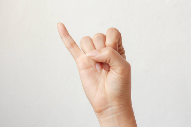 Γυναίκα χέρι υπόσχεση σημάδι, τα χέρια σφιγμένα σε μια γροθιά με μικρό δάχτυλο σε λευκό φόντο. - Φωτογραφία, εικόνα