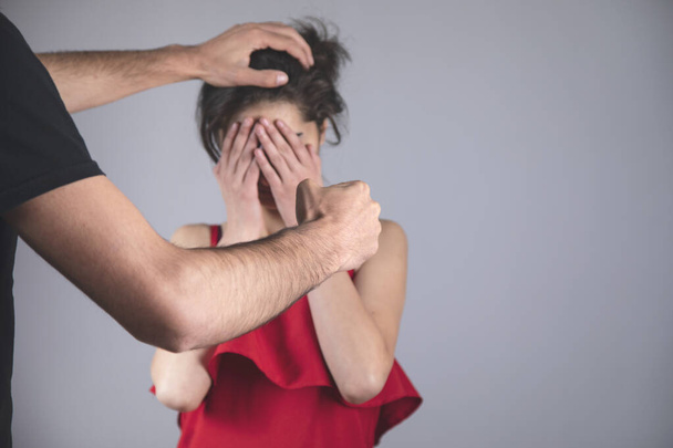 angry man beating woman on grey background - Photo, image