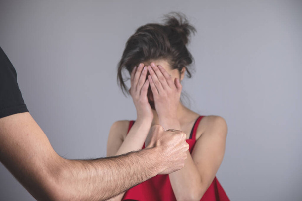 angry man beating woman on grey background - Photo, image