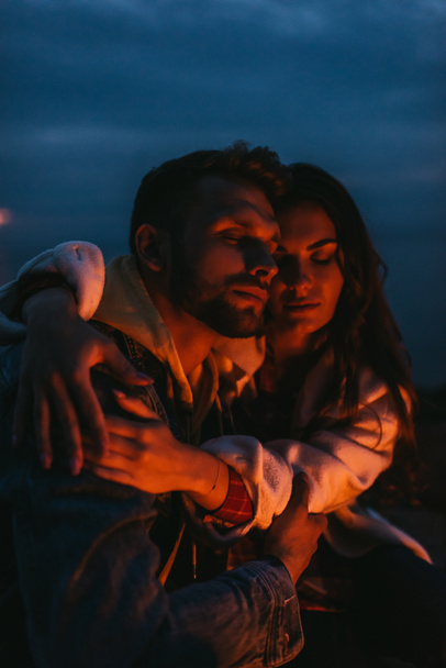 mulher atraente abraçando homem bonito à noite
 - Foto, Imagem
