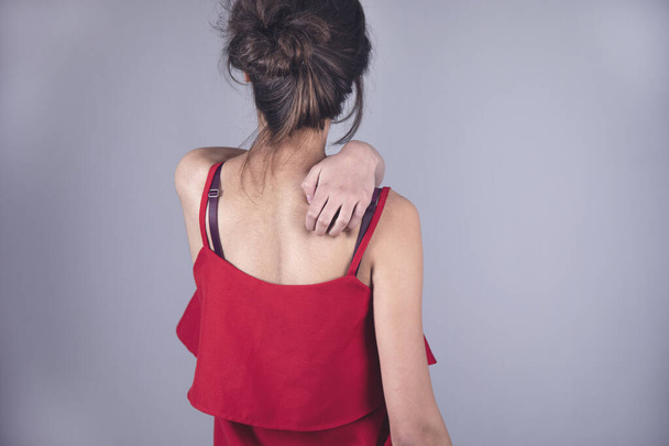 woman hand in ache back on grey background - Foto, afbeelding