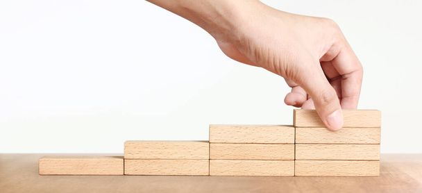 Hand arranging a wood block stacking as step stair, Business concept growth success process - Photo, image