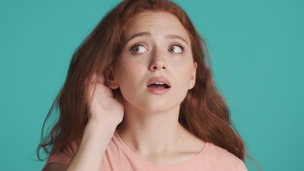 Close up attractive redhead girl trying to hear what saying over colorful background. Not hearing expression - Footage, Video