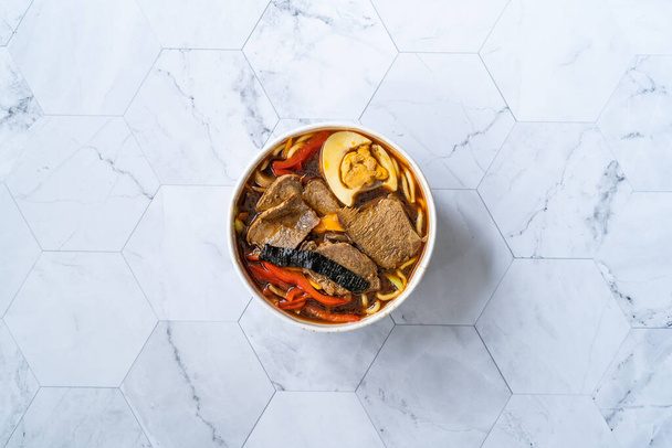 Take Away Shoyu Ramen Noodle with Egg, Soy Sprouts, Veal Meat, Carrot, Onion, Seaweed Wakame, Japanese Radish and Soy Sauce in Plastic Bowl. Healthy Traditional Fast Food. - Foto, imagen