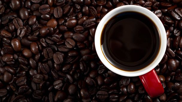 Πρωινή joe, καφεΐνη fix και καφέ χρόνο έννοια με ένα φλιτζάνι καφέ σε φρυγμένους κόκκους καφέ με αντίγραφο χώρο - Φωτογραφία, εικόνα