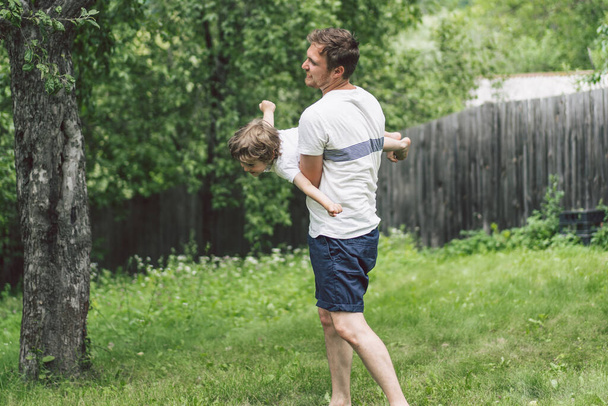 Pai e seu filho brincando e abraçando ao ar livre. Conceito do dia do Pai
.  - Foto, Imagem