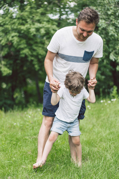 Vater und Sohn spielen und umarmen sich im Freien. Vatertagskonzept.  - Foto, Bild