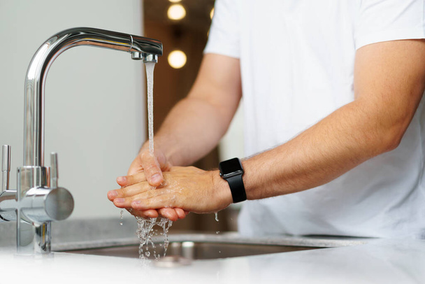 Man washing hands with soap in a sink at his home - Photo, image