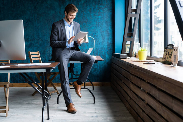 Handsome elegant businessman working on a tablet. - Photo, Image