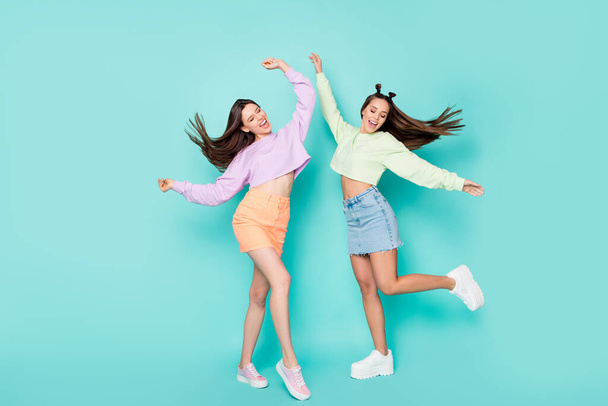 Full length body size of two nice attractive lovely slim fit slender cheerful cheery girls having fun dancing chill out isolated over bright vivid shine vibrant blue green turquoise color background - Φωτογραφία, εικόνα