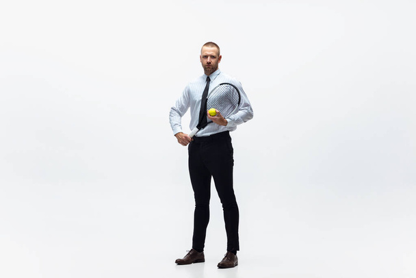 Time for movement. Man in office clothes plays tennis isolated on white studio background. - Valokuva, kuva