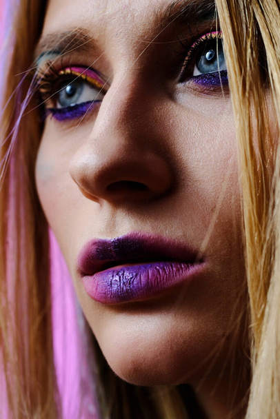 A close-up portrait of a beautiful girl of 20-25 years old with bright makeup and blue eyes. - Фото, зображення