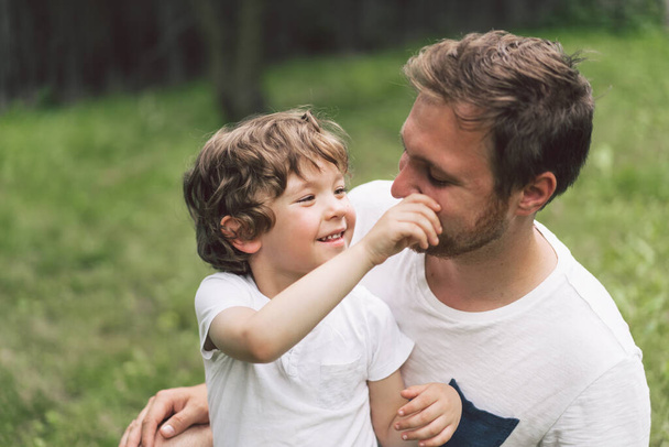 Père et son fils jouent et s'embrassent à l'extérieur. Concept de fête des pères.  - Photo, image