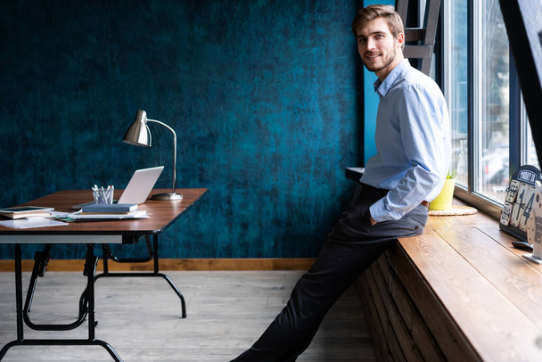Businessman wearing modern suit and stands in contemporary office. - Valokuva, kuva