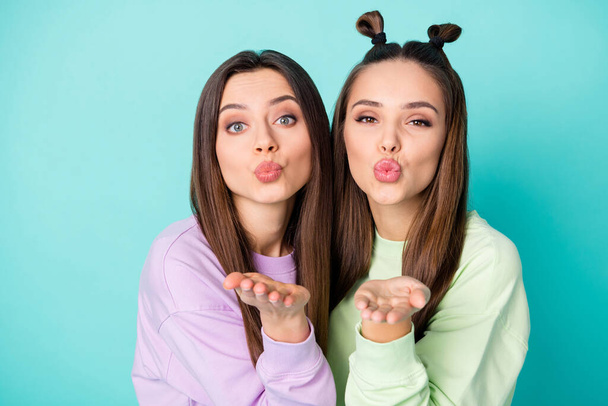 Closeup photo of two beautiful brunet lady friends hold open arms sending handsome guys air kisses wear green violet youngster sweaters isolated pastel teal color background - Fotoğraf, Görsel