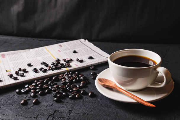 Taza de café y granos de café en papel periódico
 - Foto, imagen