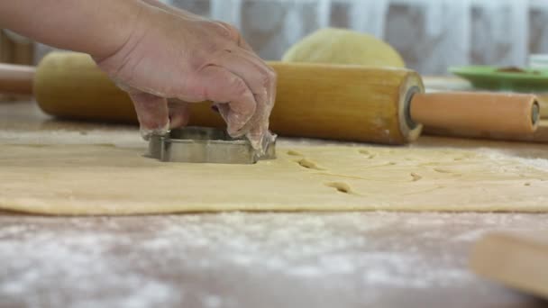 Primer plano de las mujeres manos rebanar la masa con moldes para hornear galletas danesas caseras
 - Imágenes, Vídeo