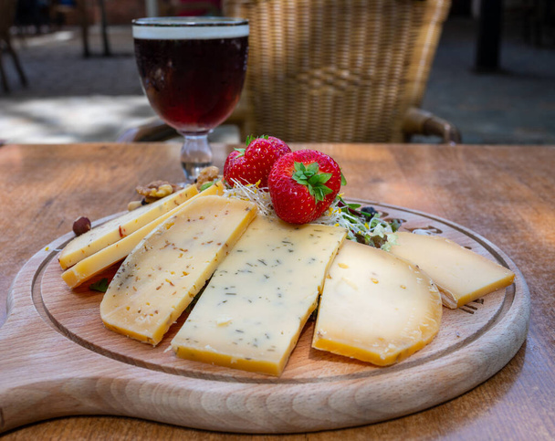Дегустация различных бельгийских сыров и темного крепкого бельгийского пива подается на открытом воздухе крупным планом - Фото, изображение