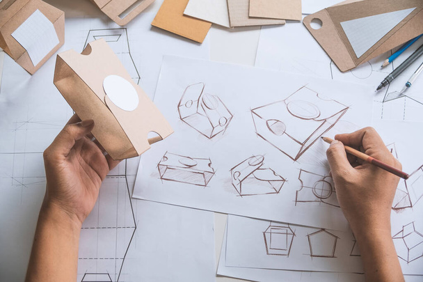 Designer sketching drawing design Brown craft cardboard paper product eco packaging mockup box development template package branding Label . designer studio concept . - Фото, изображение