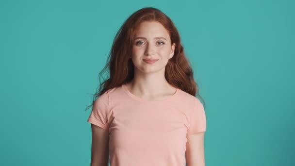 Pretty redhead girl joyfully showing thumbs up gesture on camera over colorful background. Like it expression - Footage, Video