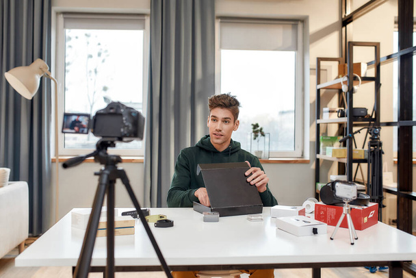 Молодий чоловічий технологічний блогер записує відео блог або блог про новий планшетний ПК та інші гаджети в домашній студії. Блог, Робота з концепції "Додому"
 - Фото, зображення