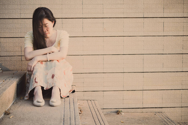 Asian woman sitting alone and depressed,stop abusing domestic violence, health anxiety. - Фото, зображення