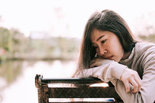 Азійка сидить сама і пригнічена, Портрет стомленої молодої жінки. Депресія - Фото, зображення