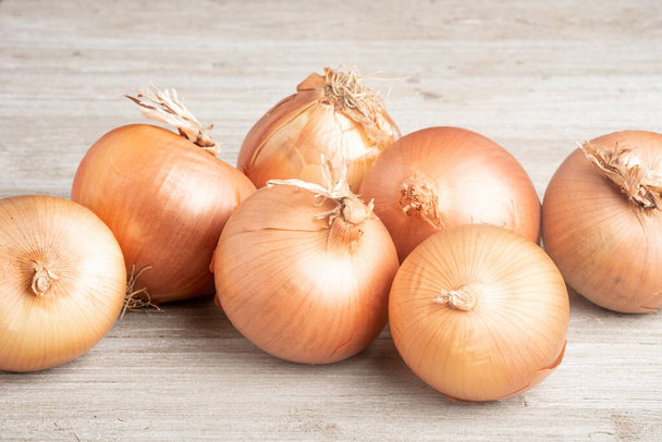 A bunch of fresh, authentic sweet southern-grown onions artfully arranged on a white painted rustic wood panel board. - Photo, Image