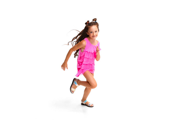 Happy little caucasian girl jumping and running isolated on white background - Foto, imagen