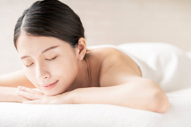 Jovem mulher sendo massageada em um salão de beleza com uma atmosfera brilhante
 - Foto, Imagem