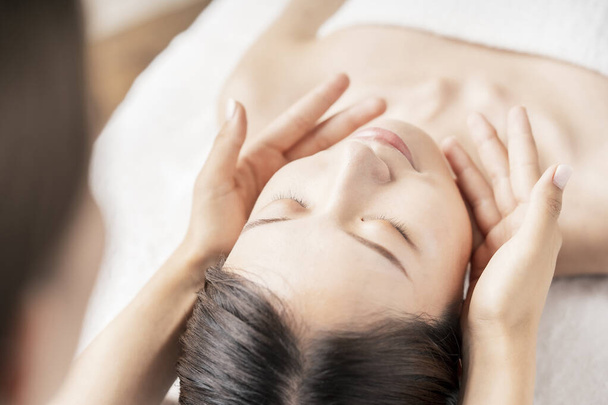 Giovane donna avendo la testa massaggiata al salone di bellezza - Foto, immagini