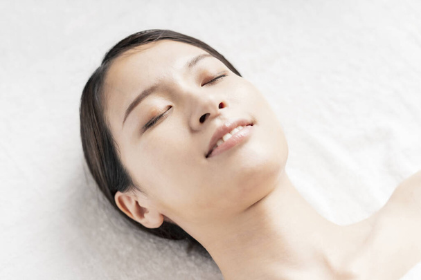 Relaxed face of young woman lying down in beauty salon - Fotografie, Obrázek