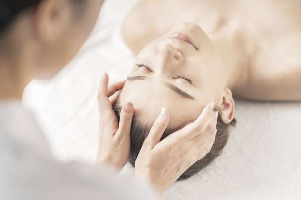 Jeune femme se faisant masser la tête au salon de beauté - Photo, image