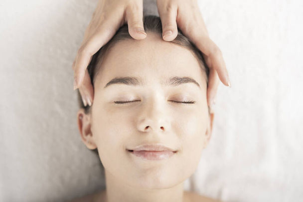 Молода жінка масажувала голову в салоні краси
 - Фото, зображення