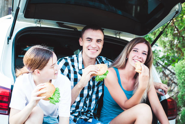 Eine Gruppe junger Leute sitzt im Kofferraum eines Autos - Foto, Bild