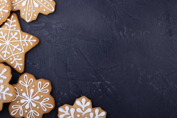 Christmas ginger cookies in the form of snowflakes on a dark background, top view. new year background with space for text - Fotografie, Obrázek