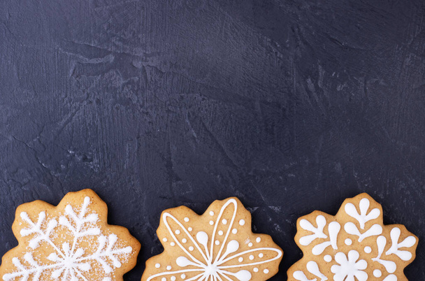 gingerbread snowflakes on a black background, top view. new year gingerbread background with space for text - Фото, изображение