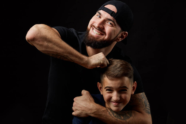 son and dad having fun on black background - Photo, image