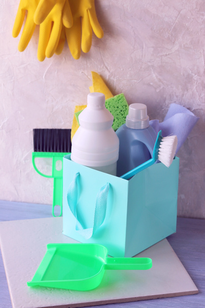 Płynne detergenty w plastikowych butelkach, gąbkach i szczotkach, gumowe rękawice do sprzątania i czyszczenia domu na drewnianym stole, dostawa do domu - Zdjęcie, obraz