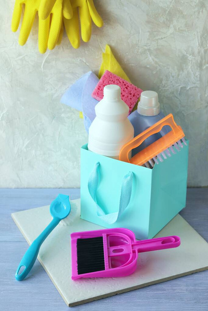 Flüssigwaschmittel in Plastikflaschen, Schwämmen und Bürsten, Gummihandschuhe für die Hausreinigung und Sauberkeit auf einem Holztisch, Hauszustellung - Foto, Bild