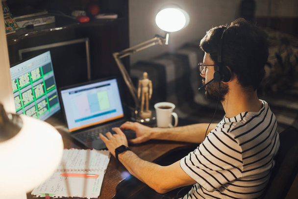Stylish bearded man working remotely from home at night - Fotoğraf, Görsel